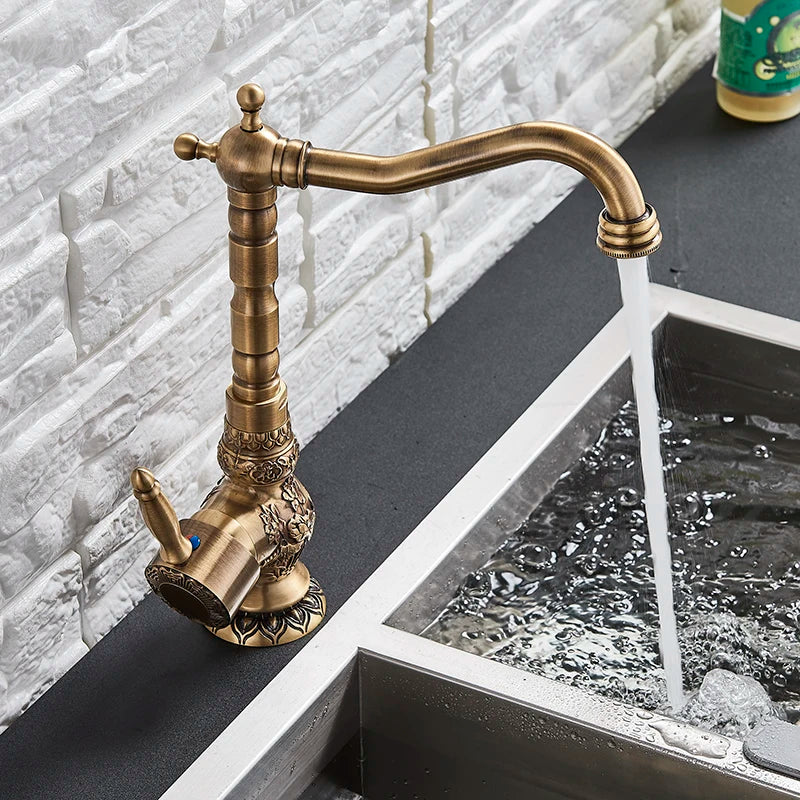 Tall antique brass gooseneck swivel faucet with a metal lever handle, shown running at a vessel sink