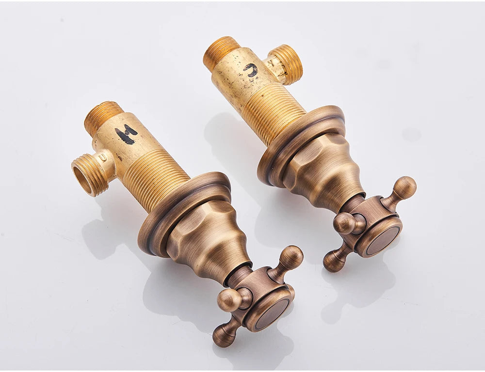 Reverse angle of the two antique brass cross-handle valves and threaded valve bodies
