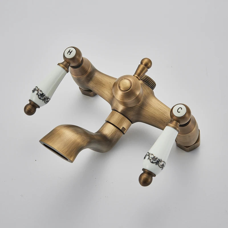 Antique brass shower column mixer with white porcelain lever handles and tub spout
