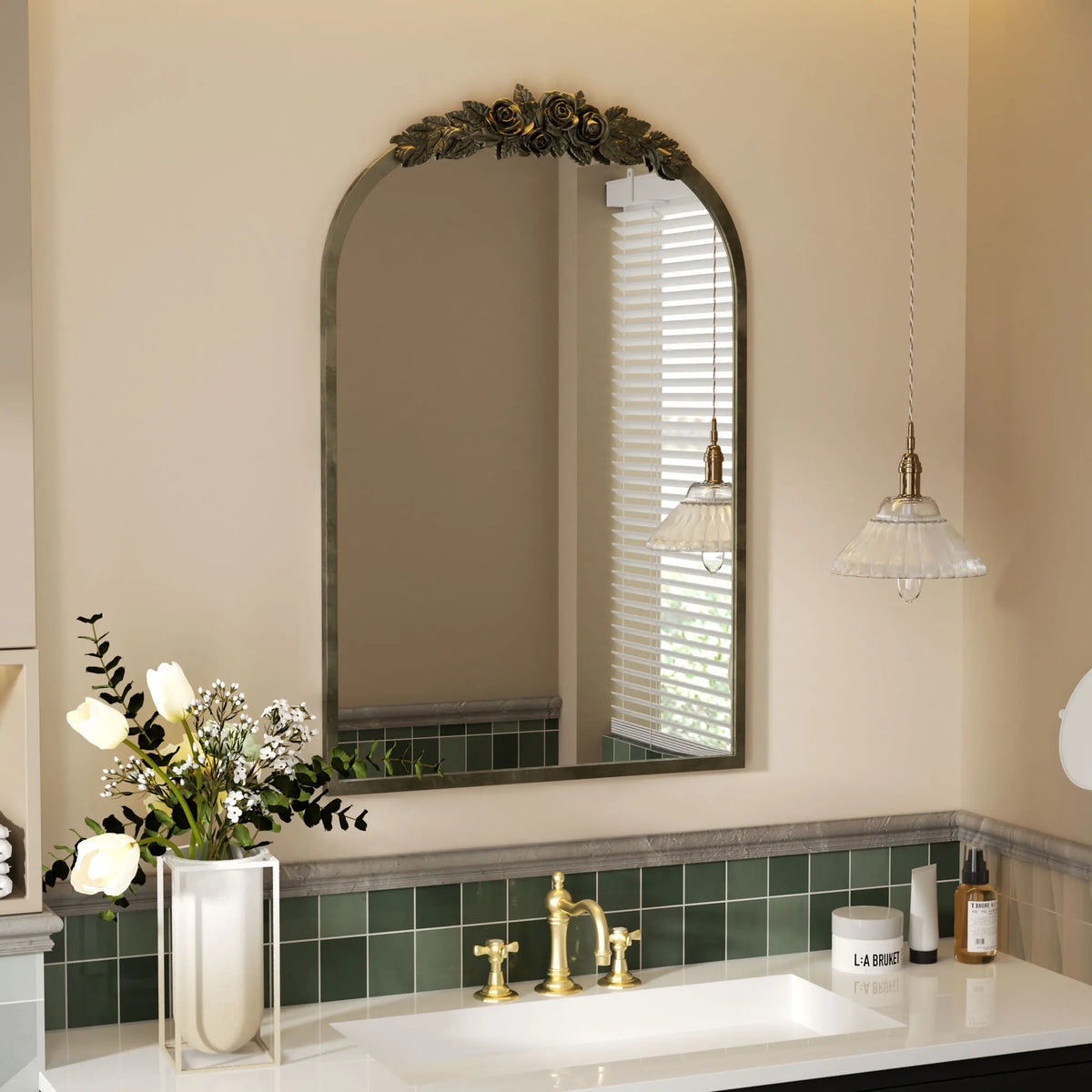 Antique brass arched mirror in a bathroom with green vanity