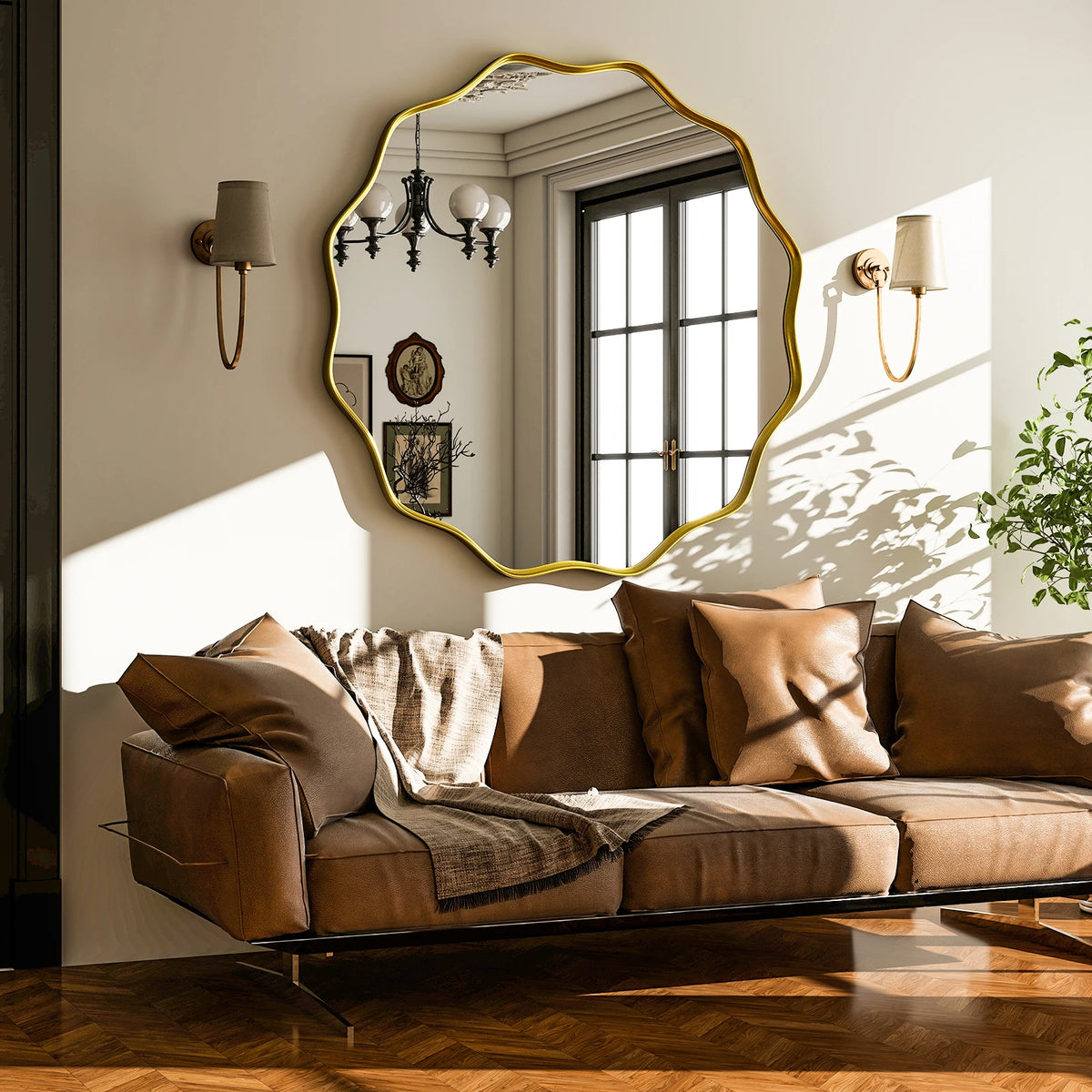 Wavy scalloped round wall mirror above a cognac leather sofa between wall sconces