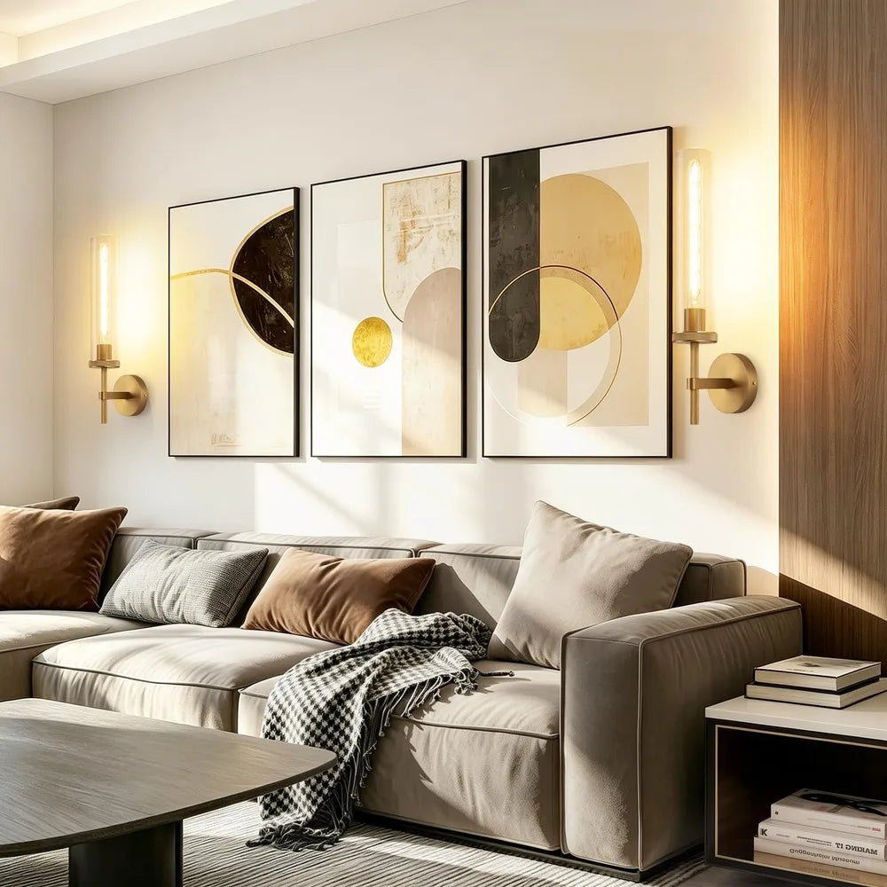 Pair of gold glass-tube wall sconces lighting a living room wall