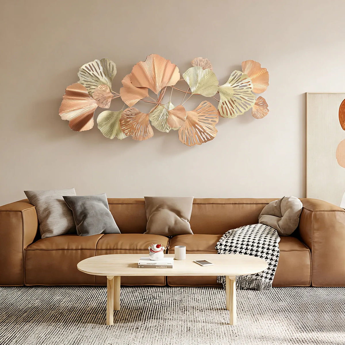 54 x 24 in ginkgo leaf metal wall art hung horizontally above a leather sofa