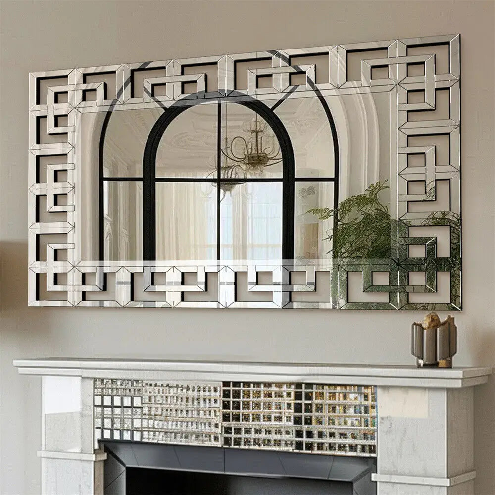 Greek-key Venetian mirrored glass wall mirror hung horizontally above a mirrored fireplace mantel