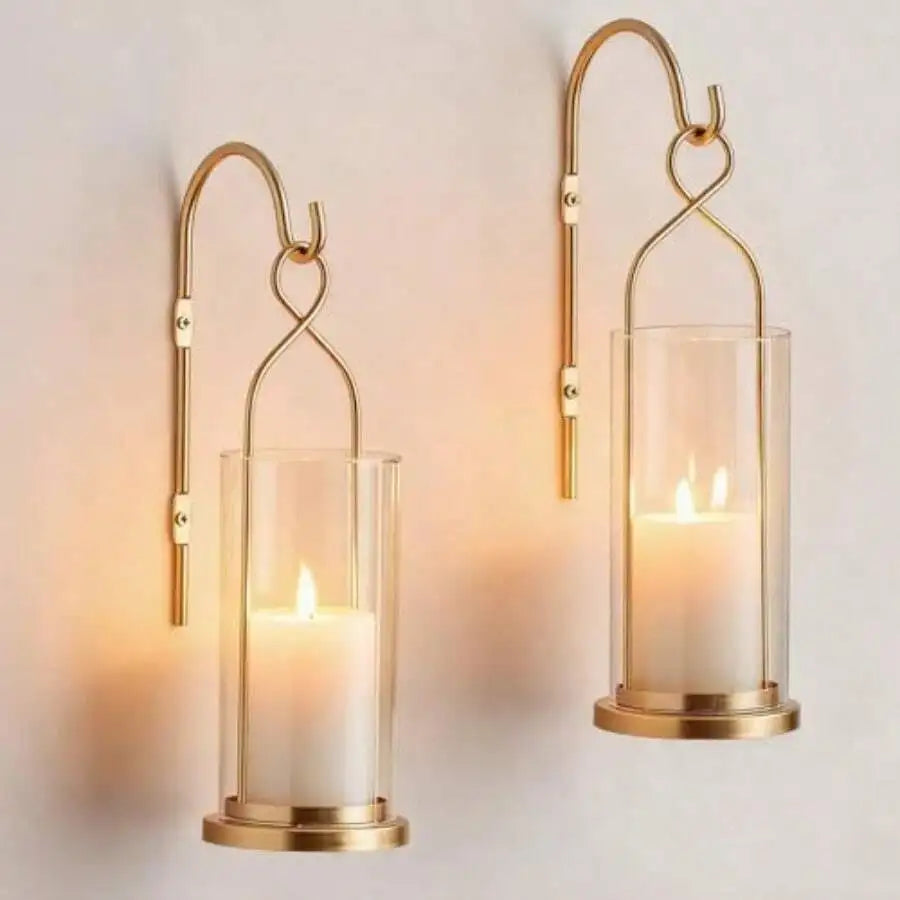 Pair of gold hurricane candle wall sconces with lit pillar candles