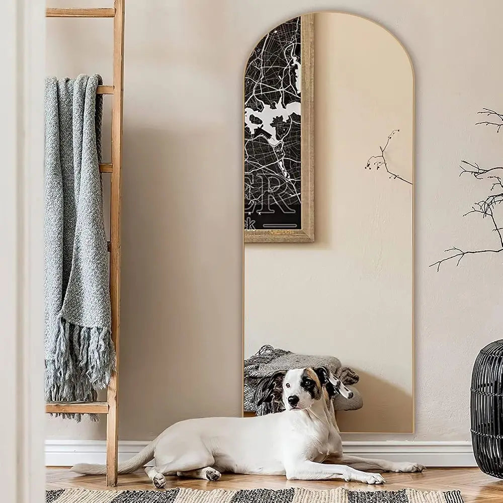 Pale wood arched floor mirror on its stand in a bright living room