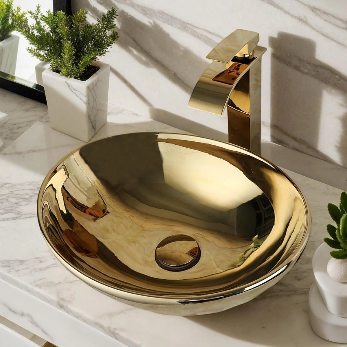 Polished gold ceramic round vessel sink with gold waterfall faucet on a marble vanity