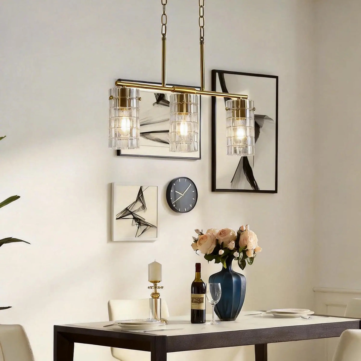 Brass three-light linear pendant with clear glass shades above a dining table