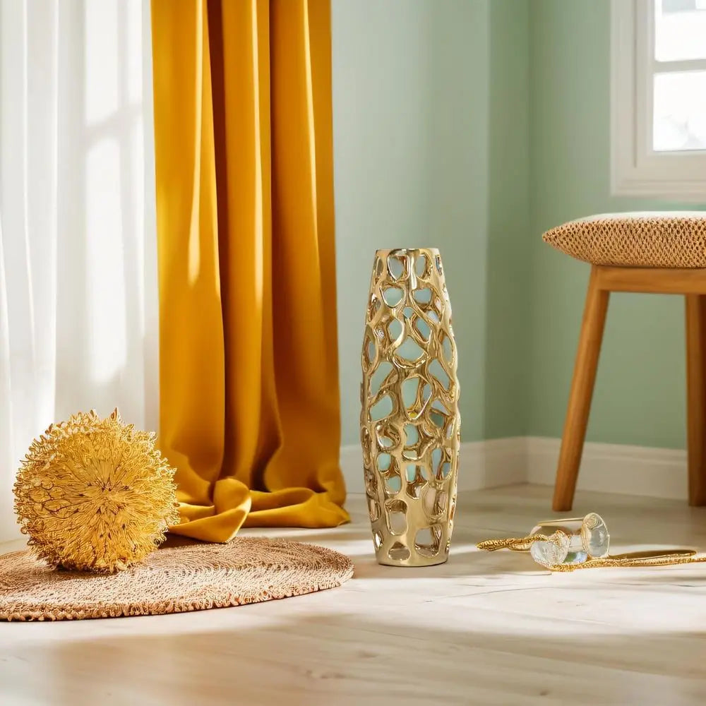 Gold openwork ceramic vase in a sunny room with mustard curtains