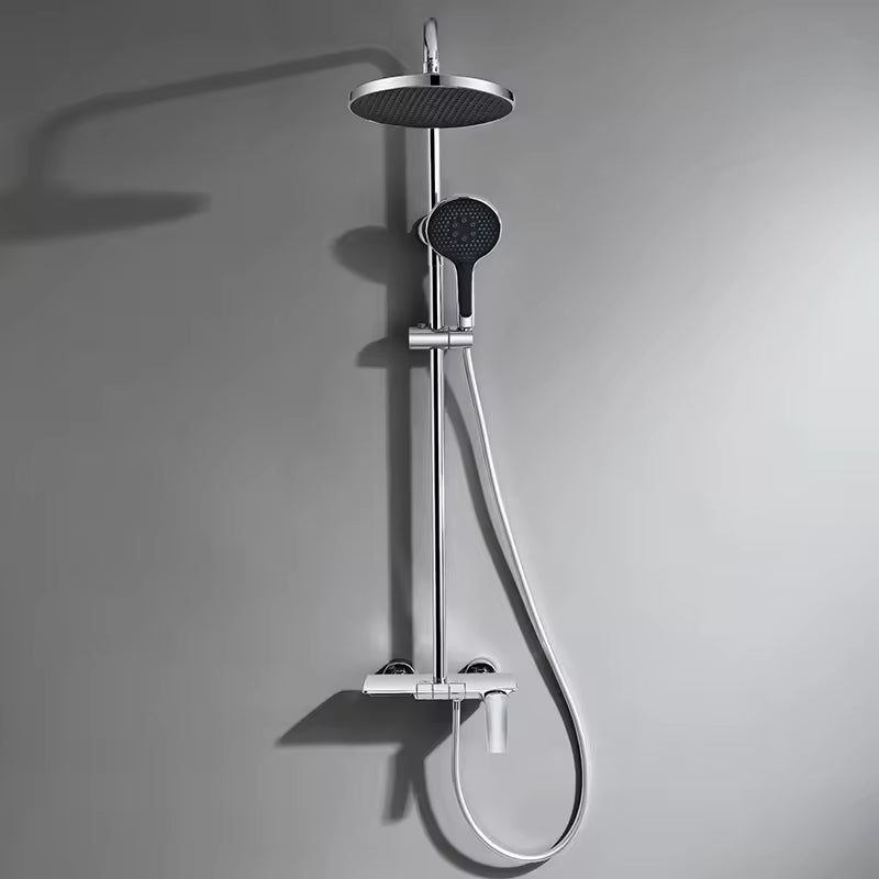 Chrome 3-way exposed rainfall shower system with round rain head, handheld shower and mixer on a grey wall