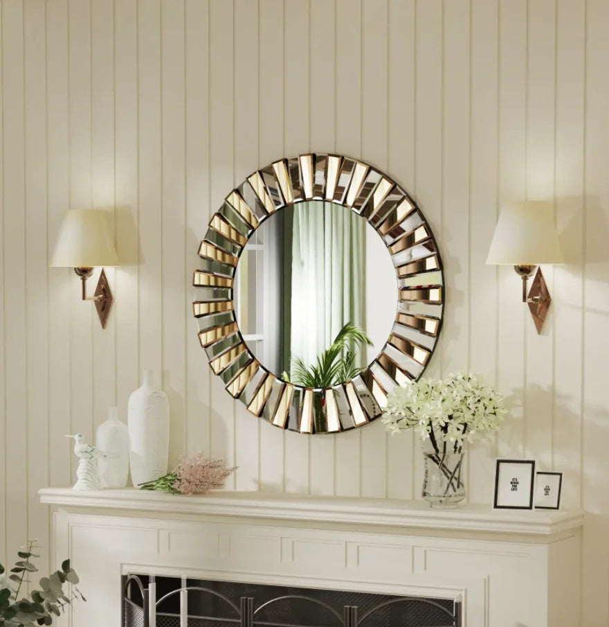 Round starburst wall mirror above a white mantel between two wall sconces