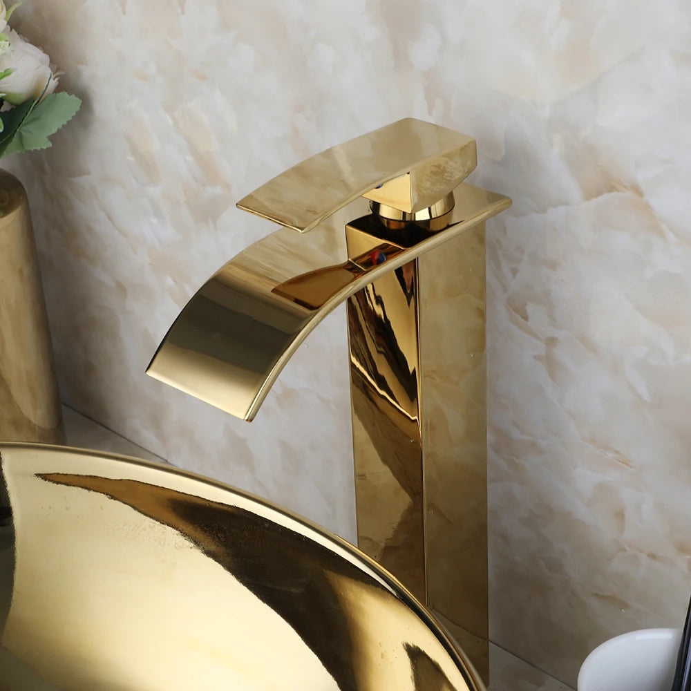 Close-up of the gold waterfall faucet spout above the polished gold vessel sink