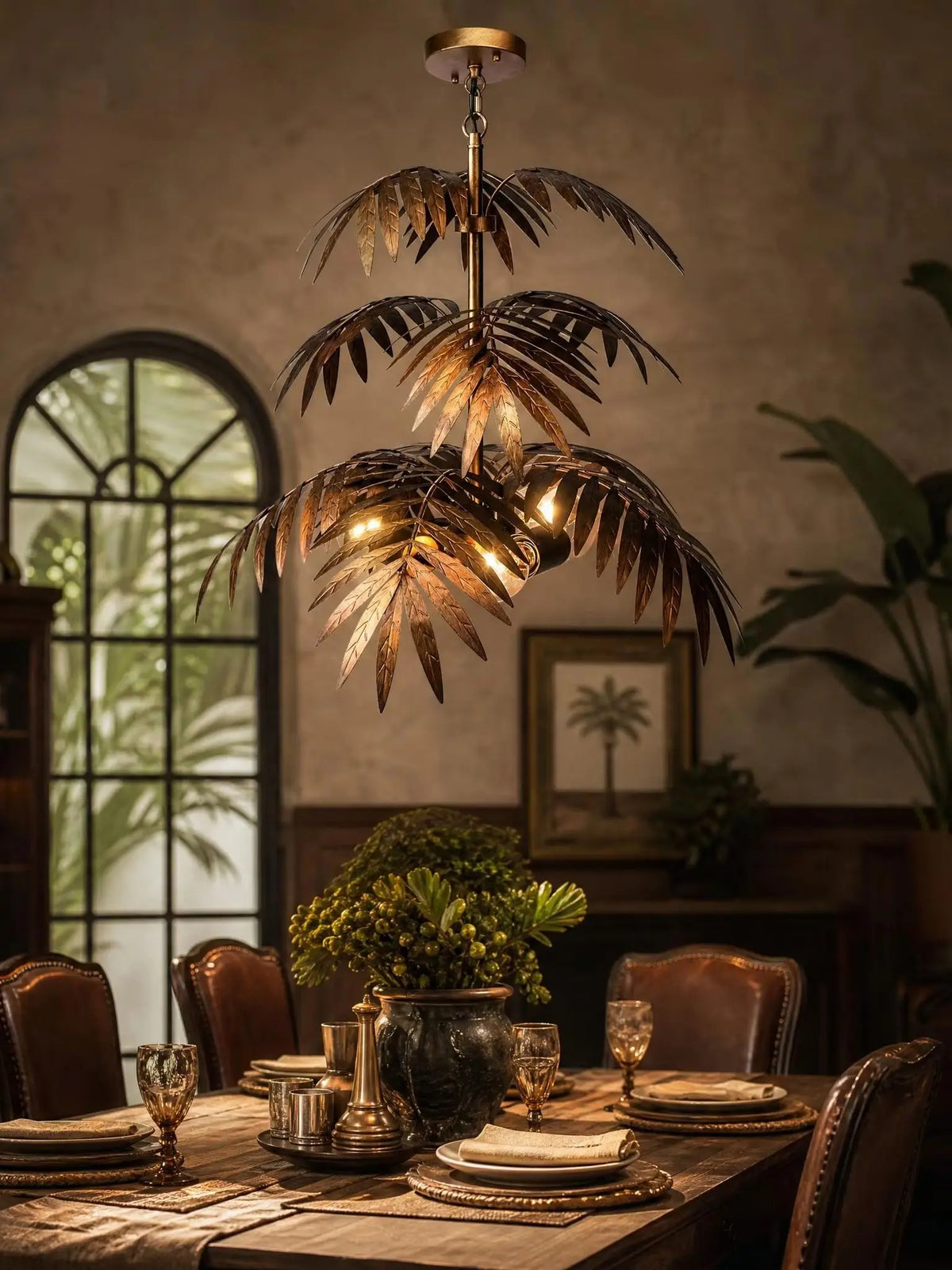 Bronze palm frond chandelier glowing in a dark room