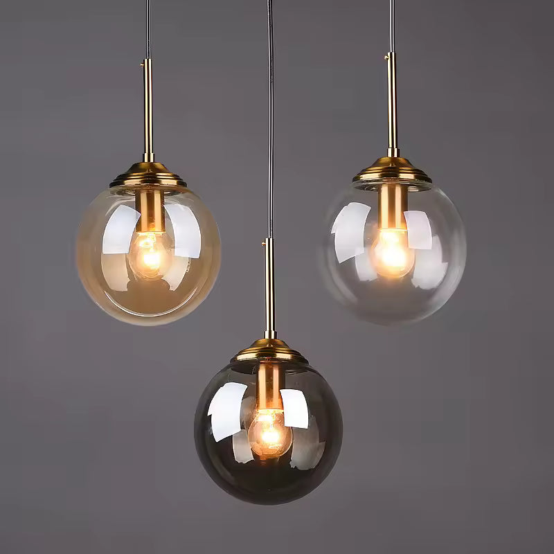 Amber, clear and smoky glass globe pendant lights with brass fittings