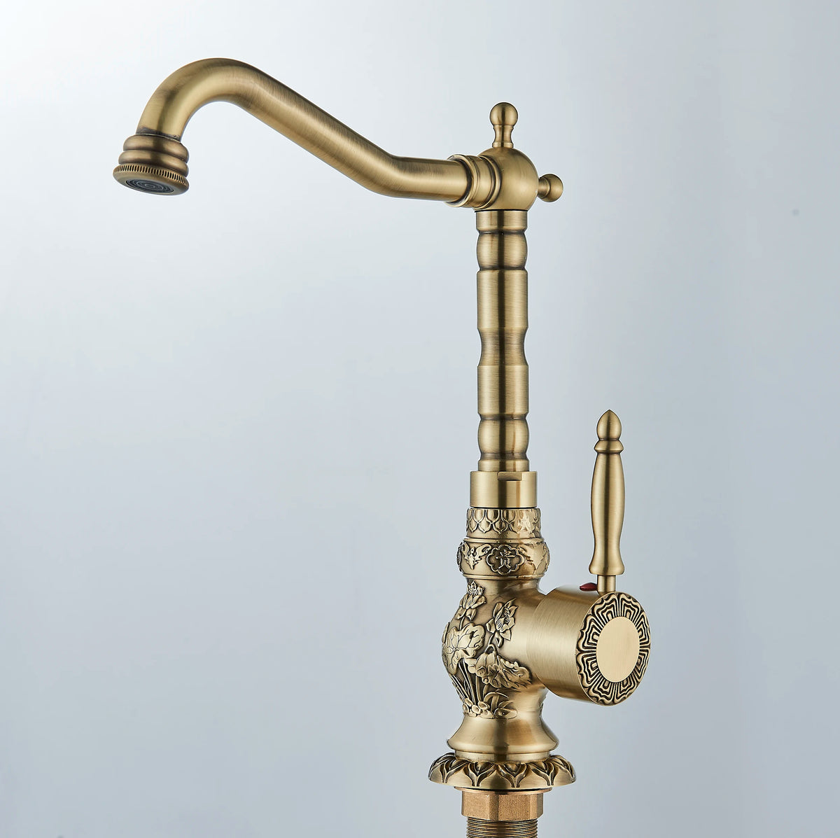 Antique brass gooseneck basin faucet with carved details