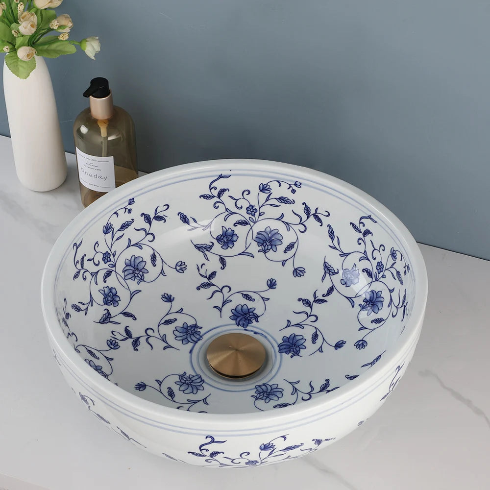 Overhead view of the hand-painted blue floral pattern and gold drain in the ceramic vessel sink