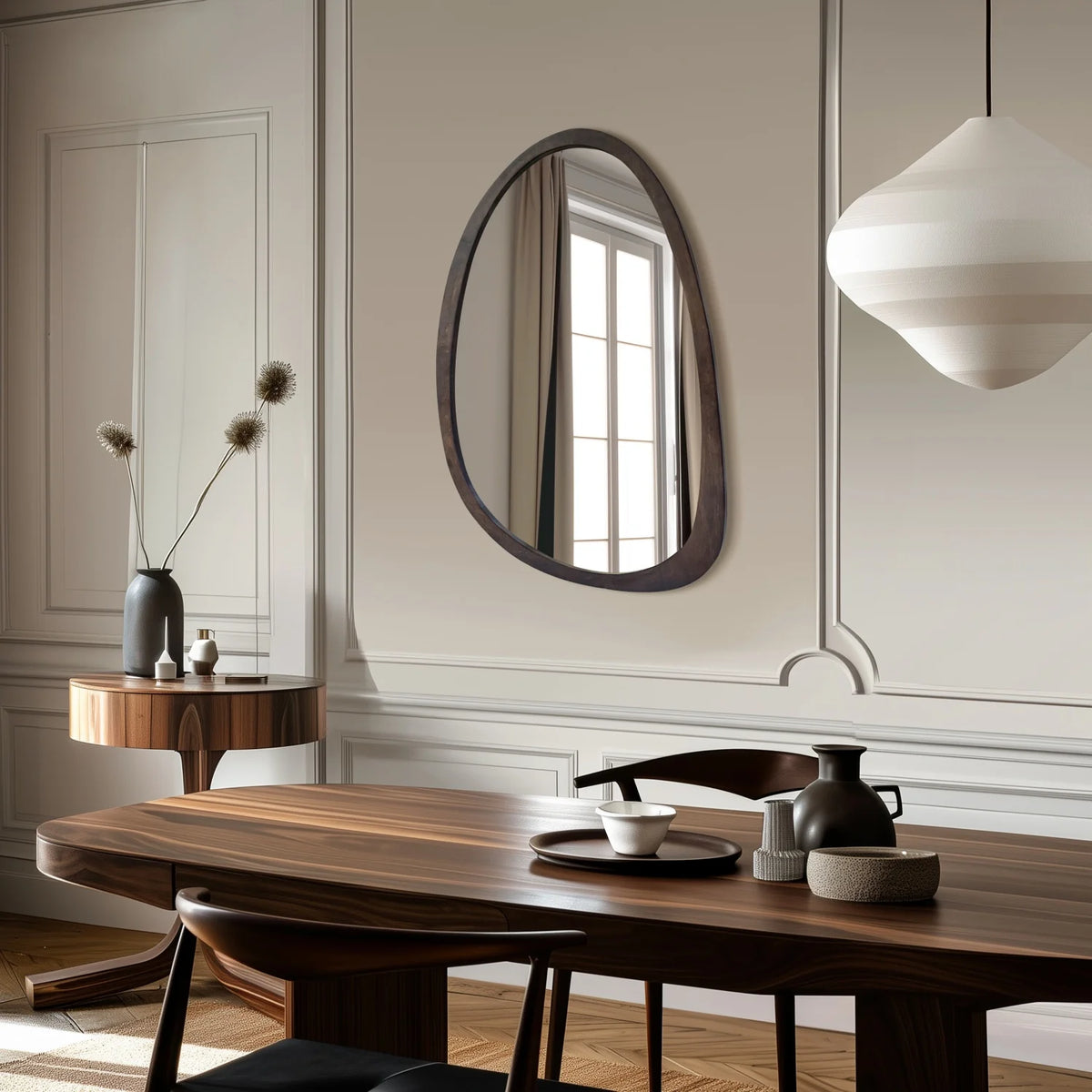 Organic walnut wood wall mirror in a dining room with wall molding and pendant light