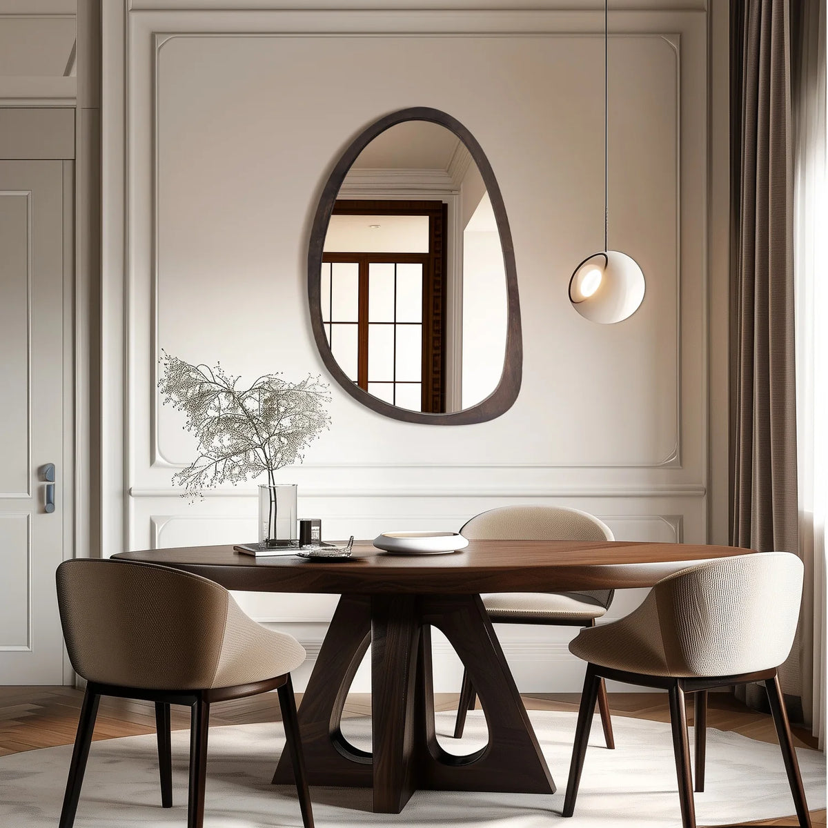 Irregular organic walnut wood mirror above a dining table with a globe pendant