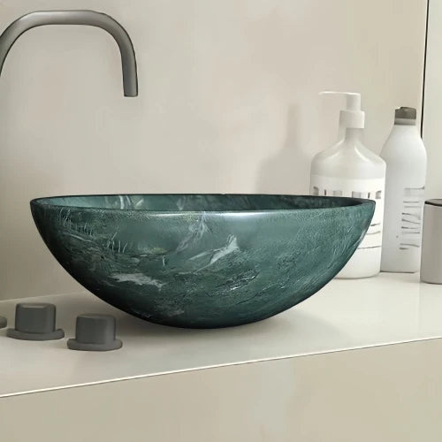 Close-up of the polished green marble vessel sink showing white veining on a counter