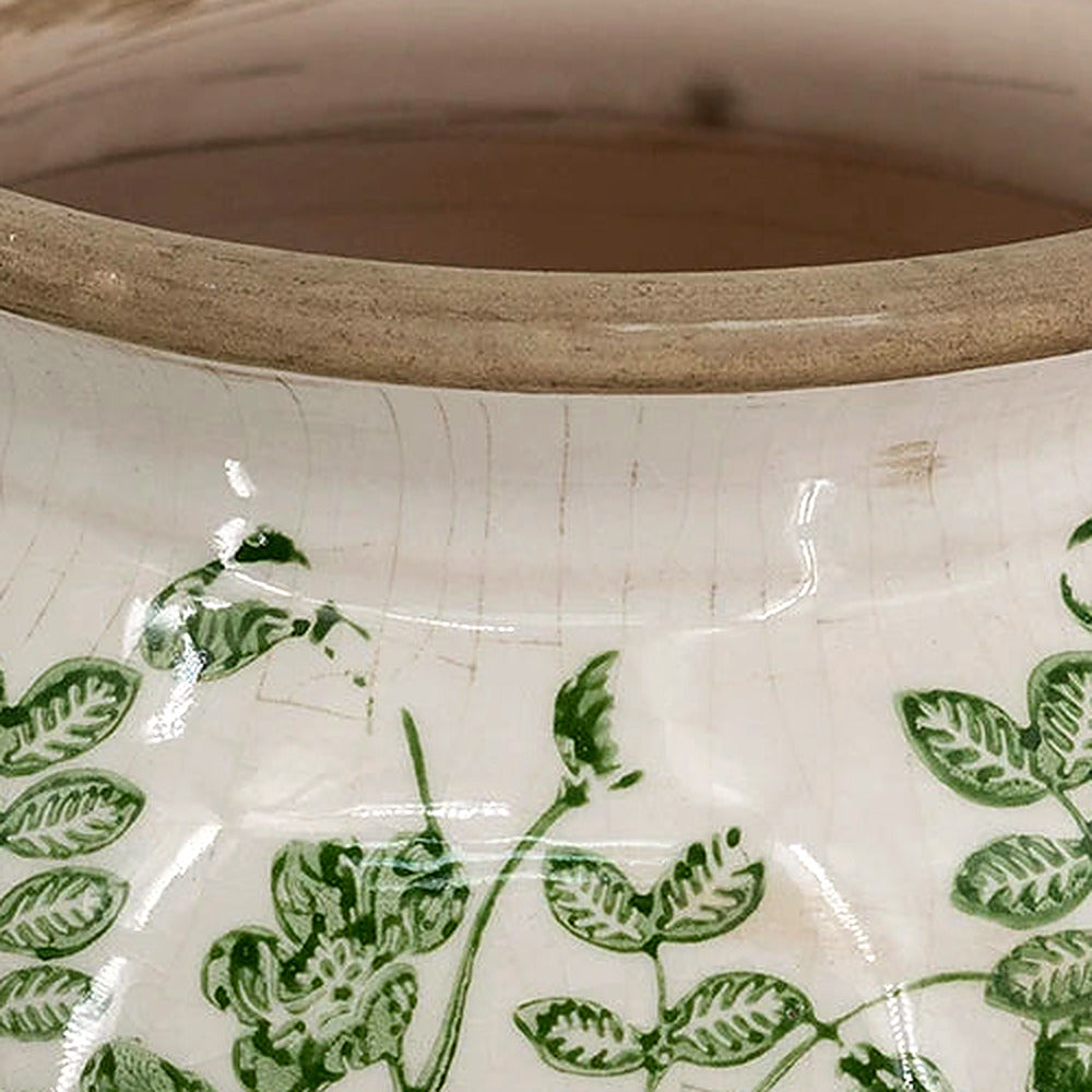 Close-up of the unglazed tan rim and green vine pattern on the crackled cream glaze