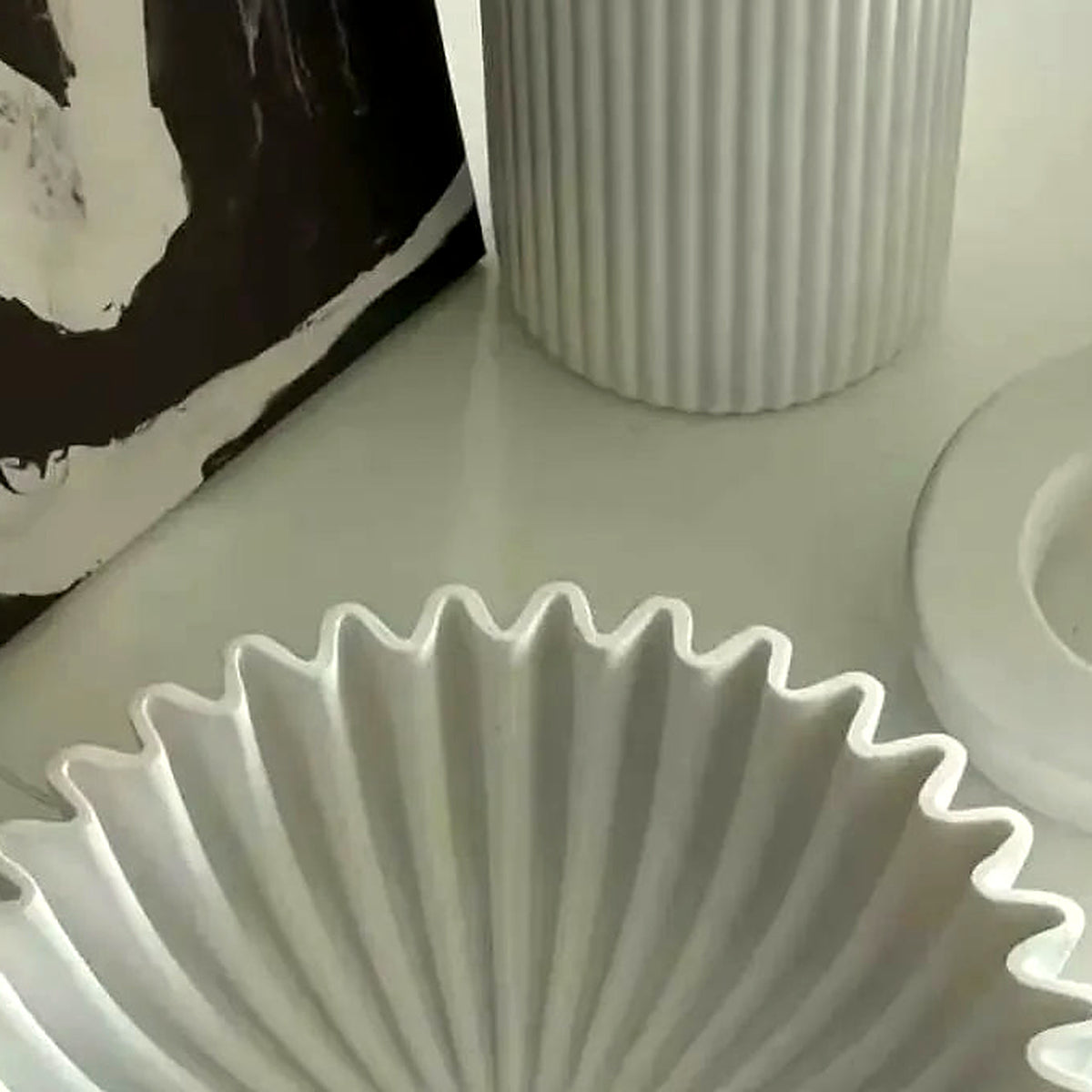 Close-up of the deep accordion pleats radiating inside the white ceramic bowl