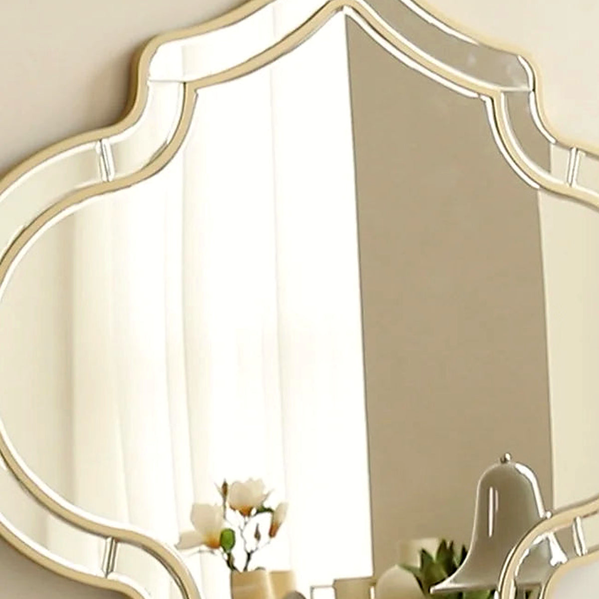 Close-up of the gold quatrefoil frame and beveled mirror border
