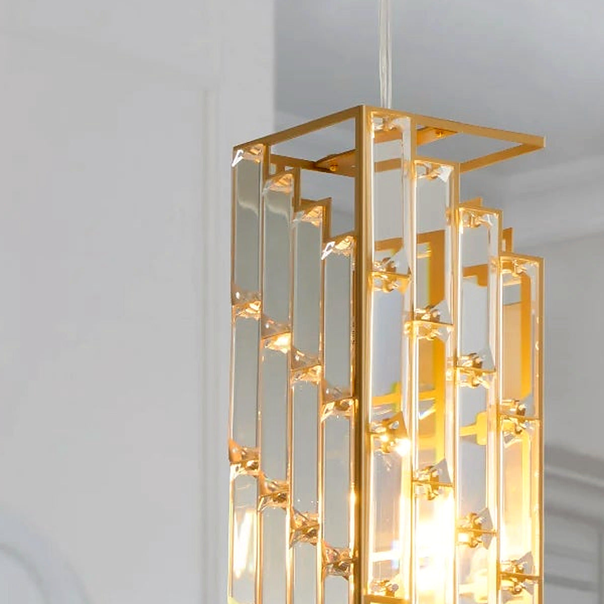 Close-up of staggered clear glass prisms clipped into an open gold rectangular frame