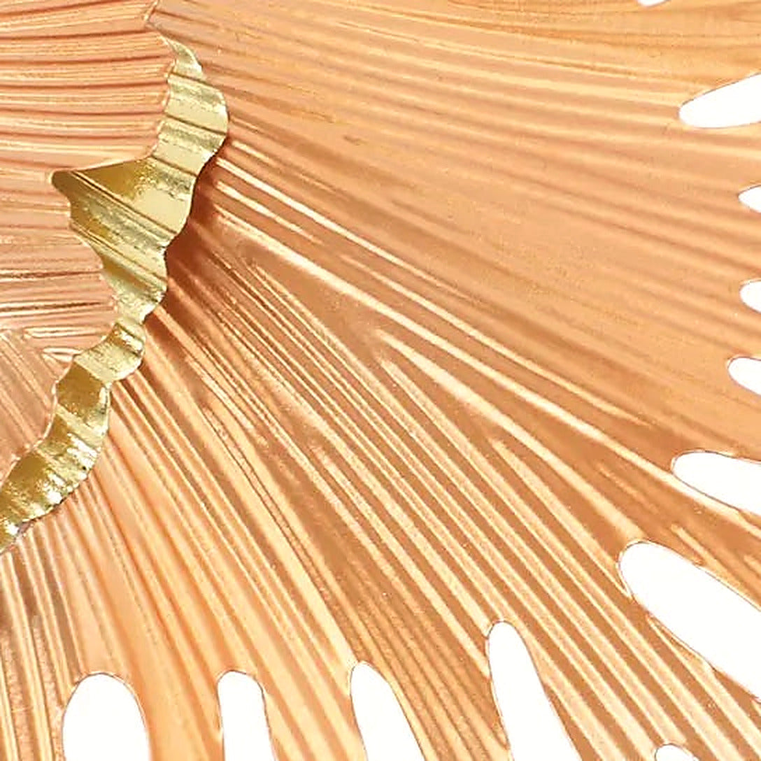 Close-up of a blush iron ginkgo leaf with finely ribbed metalwork and a gilded edge