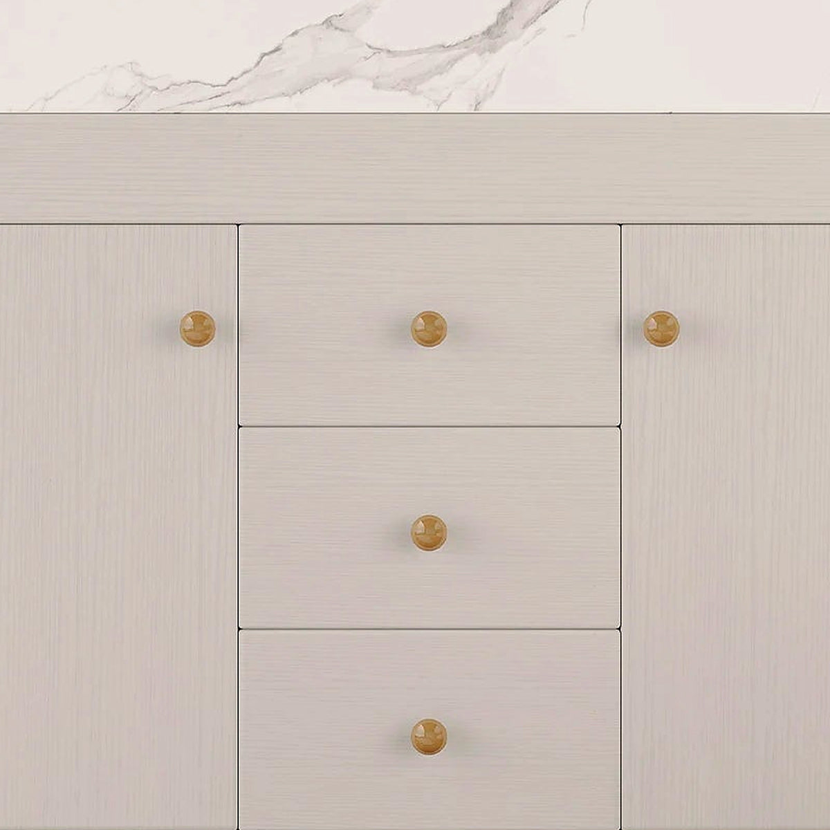Close-up of the white cabinet doors, drawers and gold knobs