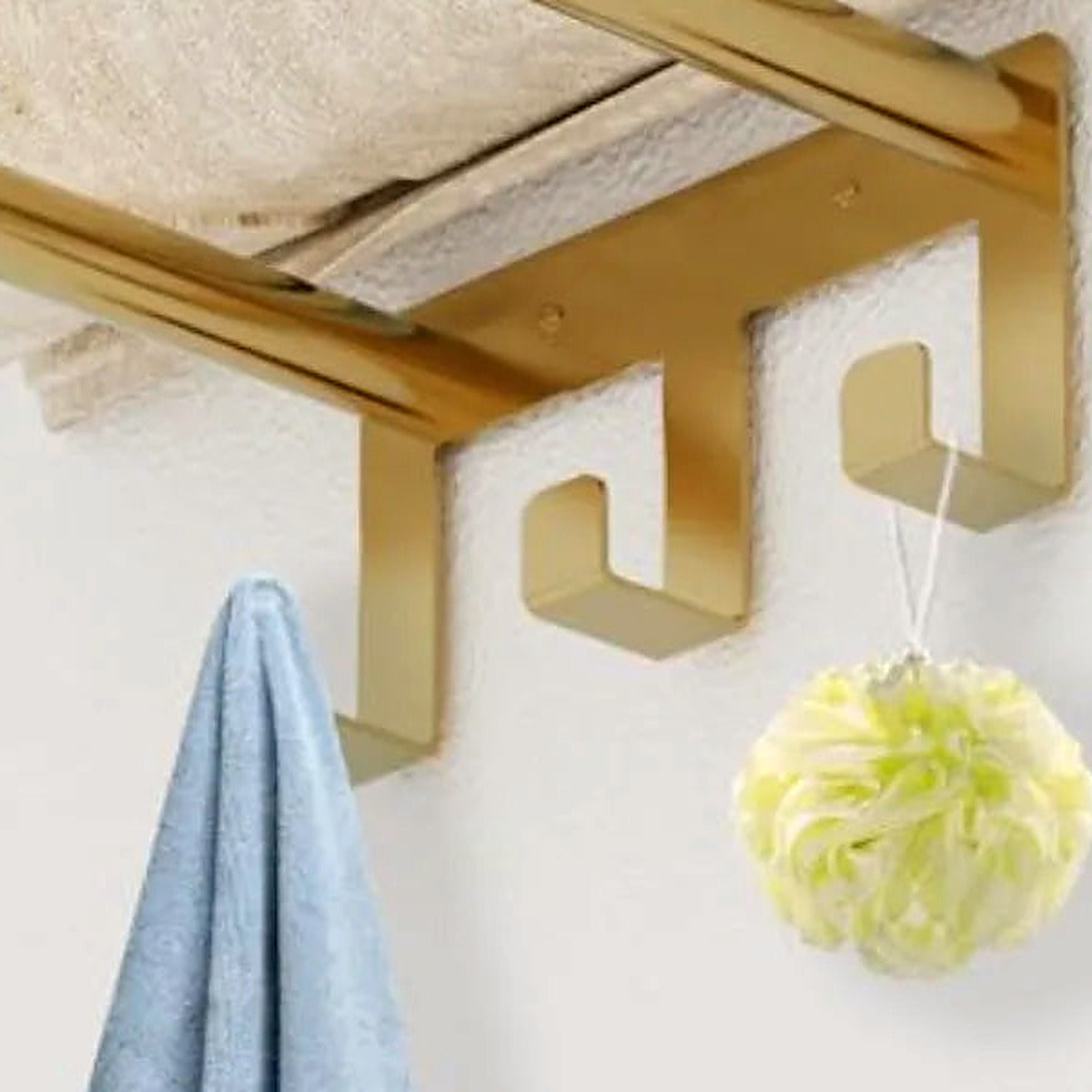 Close-up of the brushed gold square hooks at the base of the towel rack