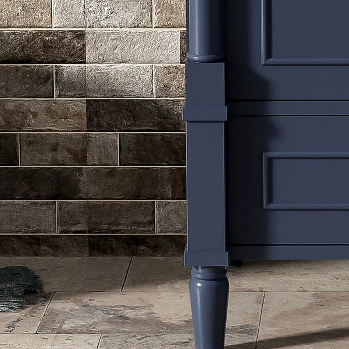 Close-up of a tapered carved French leg and the bottom drawer panel in deep navy