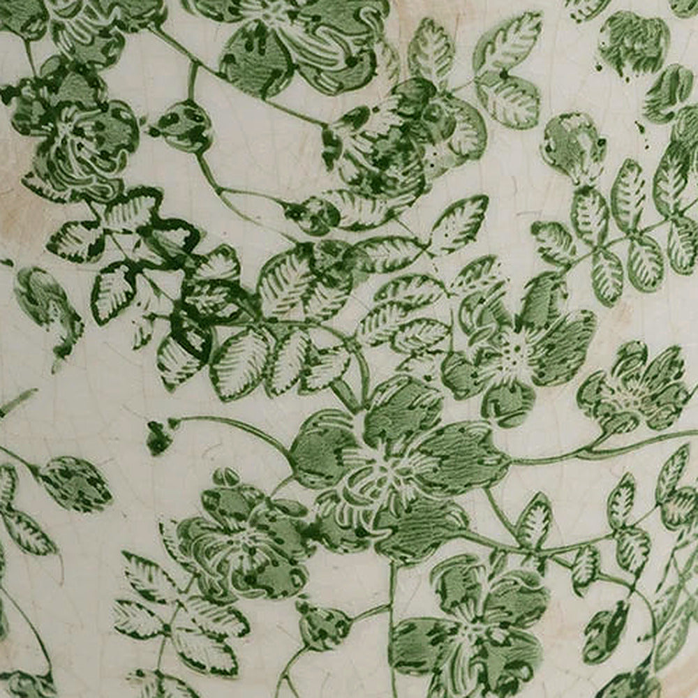 Detail of the embossed green floral trail across the white ceramic body