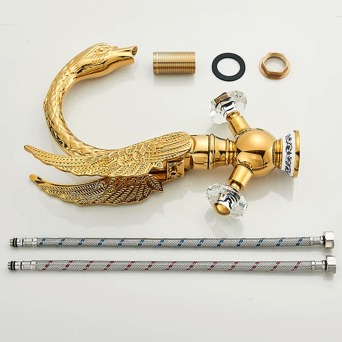 Gold swan-neck faucet body, crystal handles, supply lines and mounting hardware laid out for installation