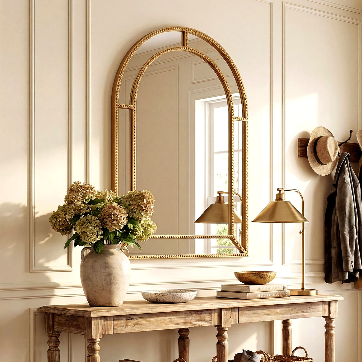 Gold beaded arched wall mirror above a wood console (furniture and décor shown for styling)