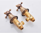 Antique brass wall-mount faucet cross-handle valves shown with their brass rough-in bodies