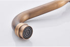 Detail of the curved antique brass faucet spout tip with recessed mesh aerator