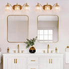 Brushed gold three-light bathroom vanity light with ribbed crystal glass shades (over a double vanity)