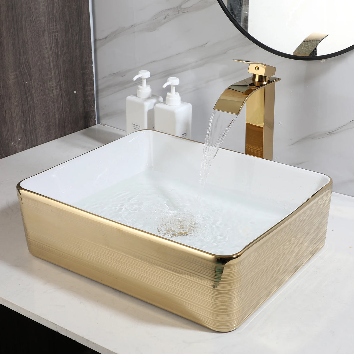 White square ceramic vessel sink with gold stripes and a gold waterfall faucet