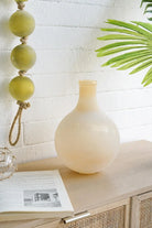 Frosted sand glass vase on a rattan console