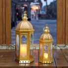 Set of two gold Moroccan candle lanterns with filigree domes and glass panels (by a doorway)