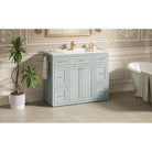 Mint green vanity styled in a bathroom with a clawfoot tub