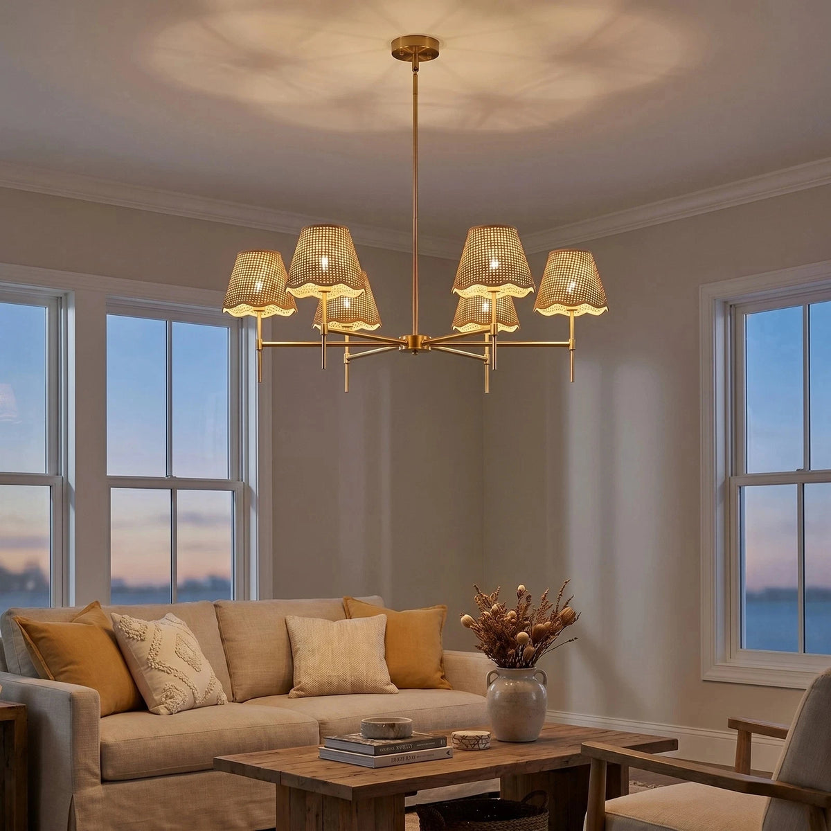 Six-Light Gold Chandelier with Rattan Shades, lit above a sofa in a coastal living room