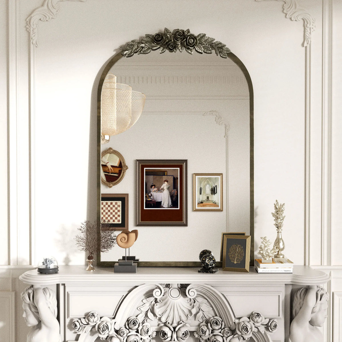 Antique silver baroque arched mirror above a carved white mantel