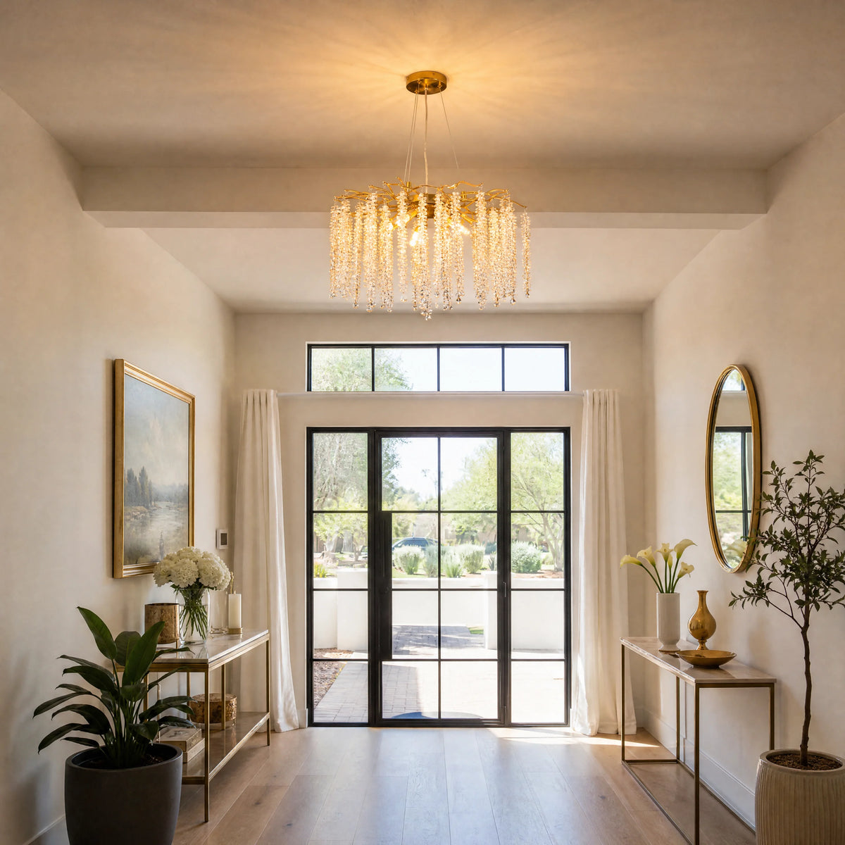 Gold branch crystal chandelier lighting an entryway with black-framed glass doors