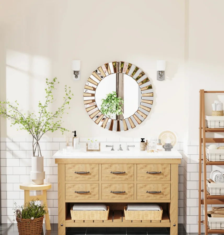 Starburst round wall mirror above a light wood bathroom vanity between sconces