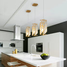 Gold crystal prism pendants above a white kitchen island