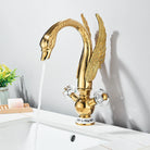 Gold swan-neck faucet installed on a white vessel sink