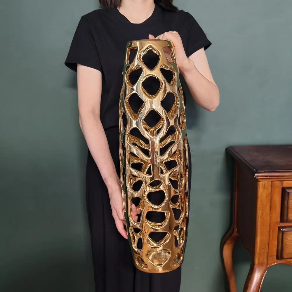 Model holding the 24-inch gold openwork vase to show its size