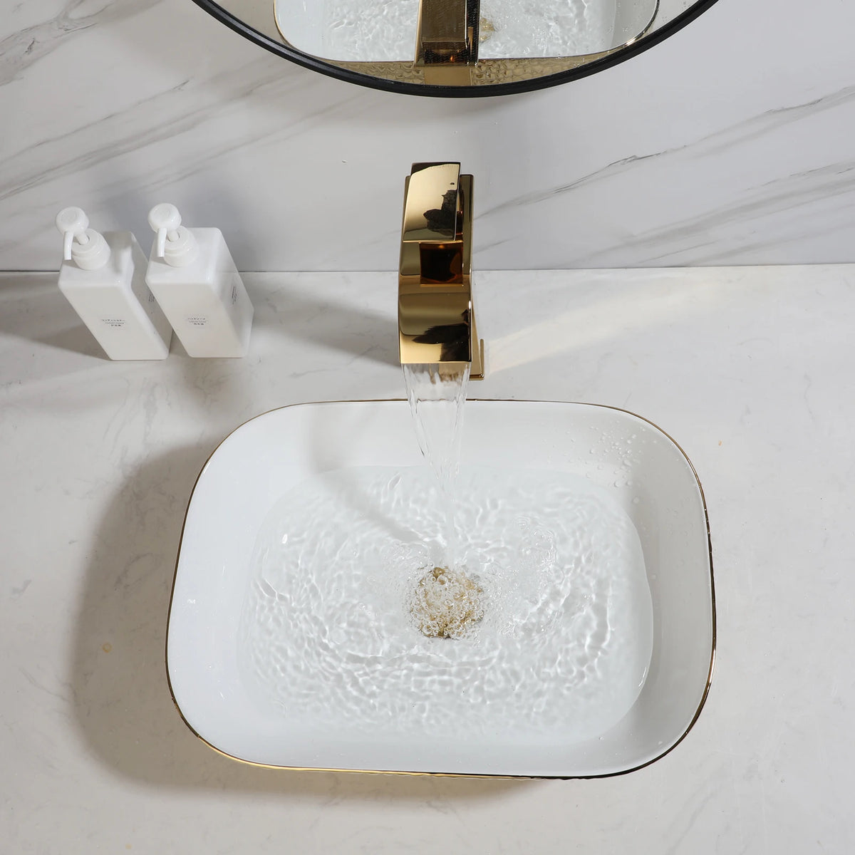 Gold waterfall faucet pouring into a hammered gold vessel sink