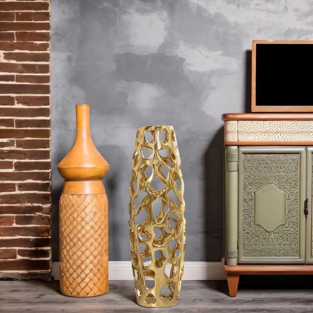 Gold openwork floor vase next to a wooden cabinet